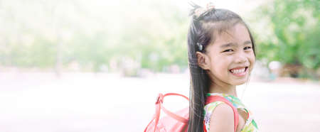 Happy asian girl arriving school from home with a backpackの写真素材