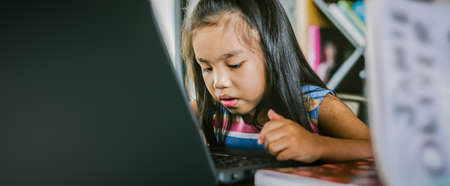 Little asian girl using laptop to studyingの写真素材