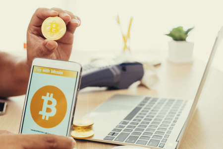 Man uses smart phone pay with bitcoinの写真素材