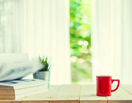 cup of coffee on wood table top and blur of curtain with window  background