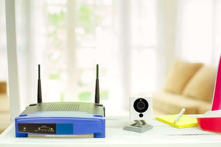 closeup of a wireless router and ip camera on living room at home with a window in the backgroundの写真素材