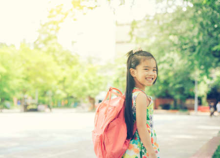 Back to school. Happy smiling girl from elementary school at the school yard.の写真素材