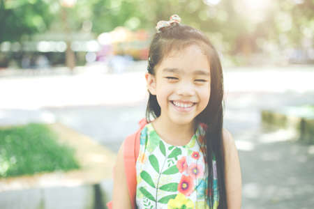 Back to school. Happy smiling girl from elementary school at the school yard.の写真素材