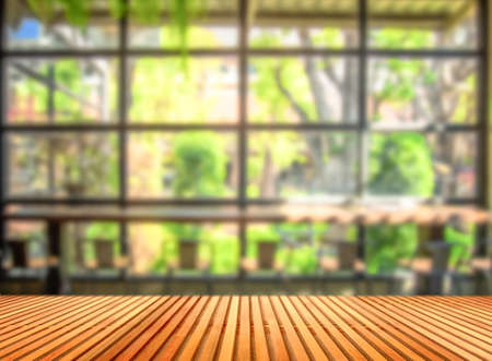 Wooden table in front of blurred  coffee shop background. can be used for display or montage your products.の写真素材