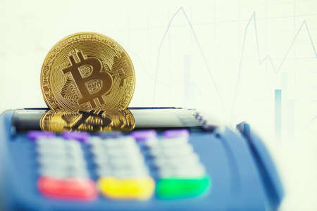 Golden bitcoin cryptocurrency on Credit card machine. Pays by bitcoin to pay a bill conceptの写真素材
