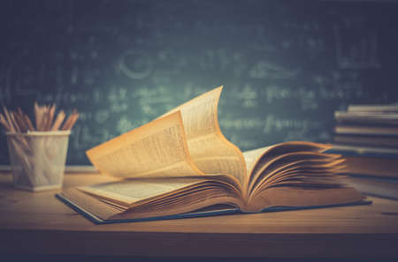 School books on desk formulas and Physics inscription on the blackboard , education conceptの写真素材