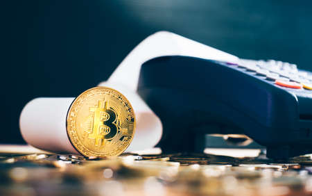 Golden bitcoin cryptocurrency on Credit card machine. pays by bitcoin to pay a bill conceptの写真素材