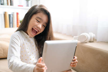 Asian young girl playing games with a tabletの写真素材