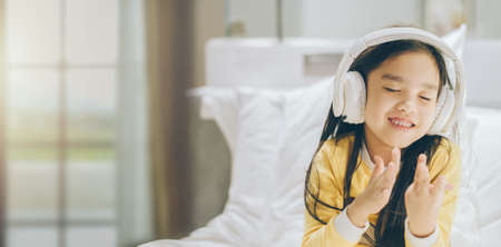 happy asian girl student listening to music with headphonesの写真素材