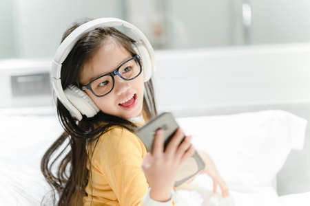 happy asian girl student listening to music with headphonesの写真素材