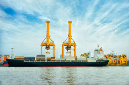 International Container Cargo ship with working crane bridge in shipyard background, logistic import export background and transport industry.の写真素材