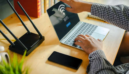 Young man Connecting router wifi On laptop  for Internet and social mediaの写真素材
