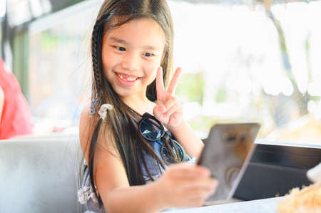smiling funny little girl with freckles doing selfieの写真素材