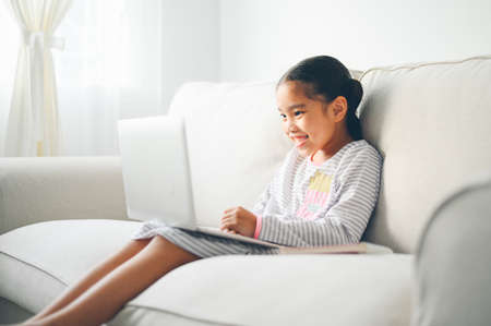 Back to School. asian Little girl using his laptopの写真素材