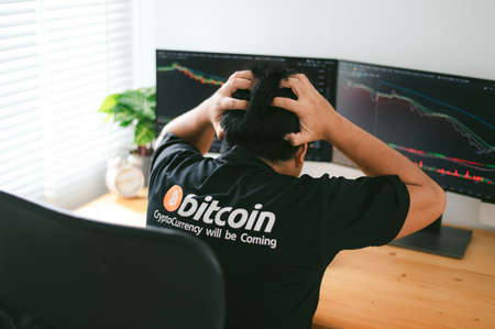 Despair man on down stock bitcoin graph market background.の写真素材