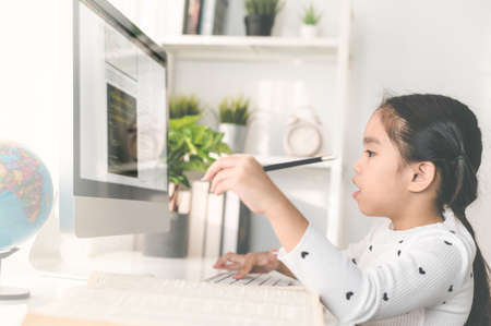 happy beautiful little girl student  using mobile pad computer studying through online e-learning systemの写真素材