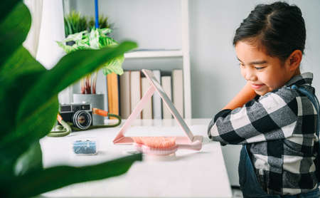 asian Little Girl Combing Hair. Smiling Lady in MirrorCombing Hair. Baby Makeup Artist. Children's Hair dressの写真素材