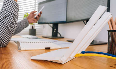closeup of a wireless router and a man using smartphone on living room at home ofiiceの写真素材