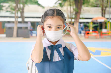 School Girl wearing mouth mask against air smog pollution in Bangkok city, Thailandの写真素材