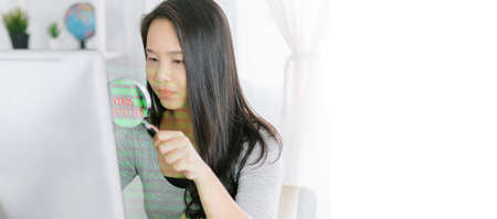 woman with magnifier glass examining a desktop computer .Scanning Files Searching Processing...