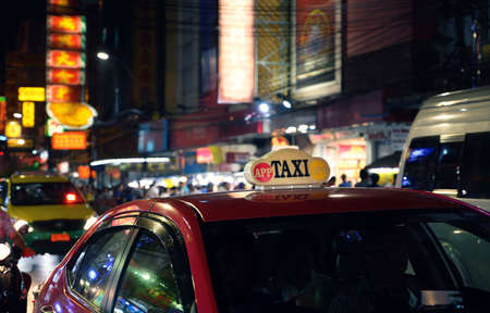 Taxi sign with defocused lights blur in Chinatown in Bangkok at night , Thailand , Southeast asiaのeditorial素材