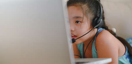 asian girl student wear headphone watch webinar listen online course communicate by conference video call. . Homeschooling and distance learning ,online ,internet protect from COVID-19 viruses.の写真素材