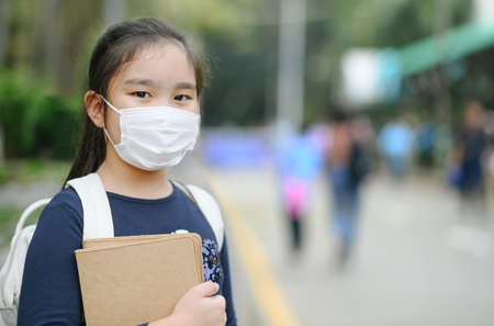 Back to school. asian child girl wearing face mask with backpack  going to school .Covid-19 coronavirus pandemic.New normal lifestyle.Education concept.の写真素材