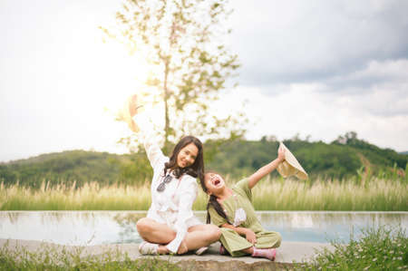 Mother and daughter having fun  in summer. Happiness and harmony in family life. Beauty nature scene with family outdoor lifestyle.の写真素材