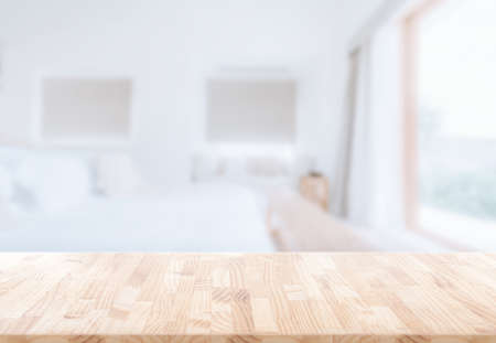 Wooden table top in front of blurred bedroom interior background.  for montage or display your productsの写真素材