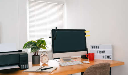 Modern office interior with electronic device, supplies and coffee cup on tableの写真素材