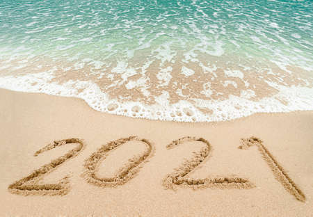 Happy New Year 2021, lettering on the beach with wave and blue sea. Numbers 2021 year on the sea shore, New Years concept.の写真素材