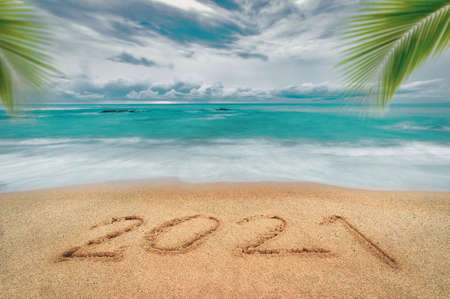 Happy New Year 2021, lettering on the beach with wave and blue sea. Numbers 2021 year on the sea shore, New Years concept.の写真素材