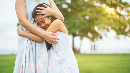 Happy family mother and daughter  hugging her mother outdoor in summer park.の写真素材