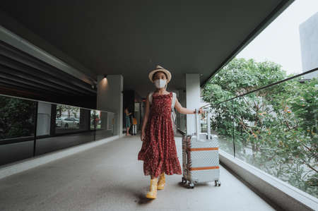 Pretty asian girl happy tourists to travel wearing mask to protect from Covid-19 on they holidaysの写真素材