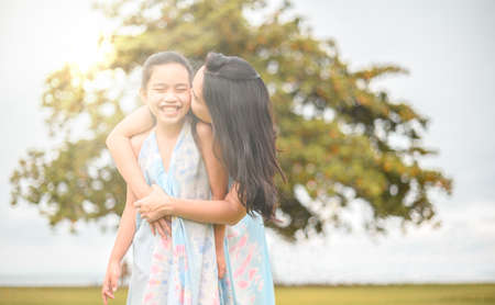 Happy family mother and daughter on nature on sunsetの写真素材