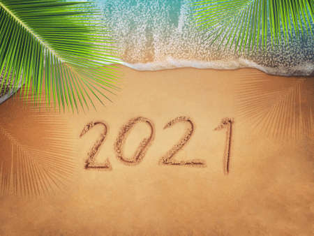 Happy New Year 2021, lettering on the beach with wave and blue sea. Numbers 2021 year on the sea...