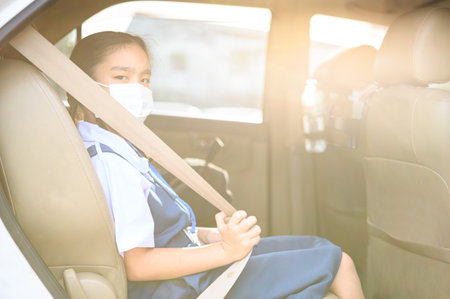 Asian kid girl student wearing mask to protect the coronavirus Covid-19 outbreak situation before go to school. Get ready to school concept.の写真素材