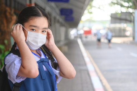 Back to school. asian child girl wearing face mask with backpack going to school .Covid-19 coronavirus pandemic.New normal lifestyle.Education concept.の写真素材