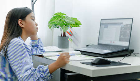 Asian girl doing homework or online education