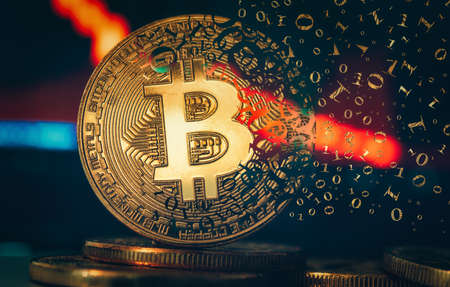 Crypto currency golden coin. Gold bitcoin falling apart. Concept of a cryptocurrency market crisis and defocused chart background.の写真素材