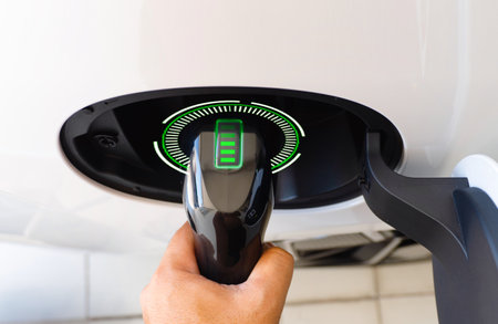 Electric car or ev is charging at station . man use the white power cable and plug on nature backgroundの写真素材