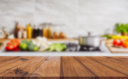 Wood table top on blurred kitchen background. can be used mock up for montage products display or design layoutの写真素材