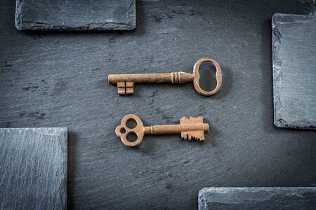 Old, rusty keys on the stone tableの写真素材
