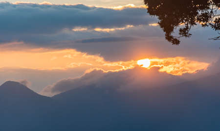sunrise over a volcano between clouds