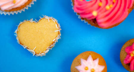 table of sweets and cupcakes with icing and sparklesの写真素材