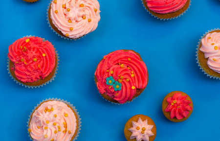 table of sweets and cupcakes with icing and sparklesの写真素材