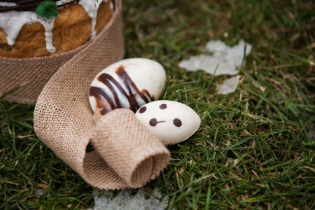 Easter cake in eco-style decorated with chocolate eggs in a nest on the background of spring grass...