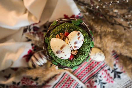 Easter pie in eco-style decorated in the form of a nest with eggs on the background of the national...