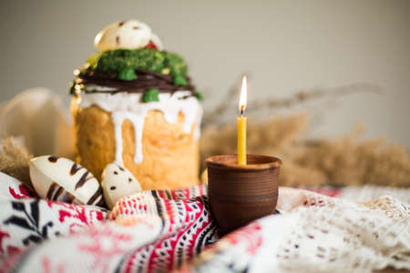 Easter pie in eco-style decorated in the form of a nest with eggs on the background of the national traditional towelの写真素材