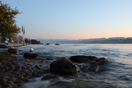Lake of Zurich at sunset, blurred wave and orange leavesの写真素材